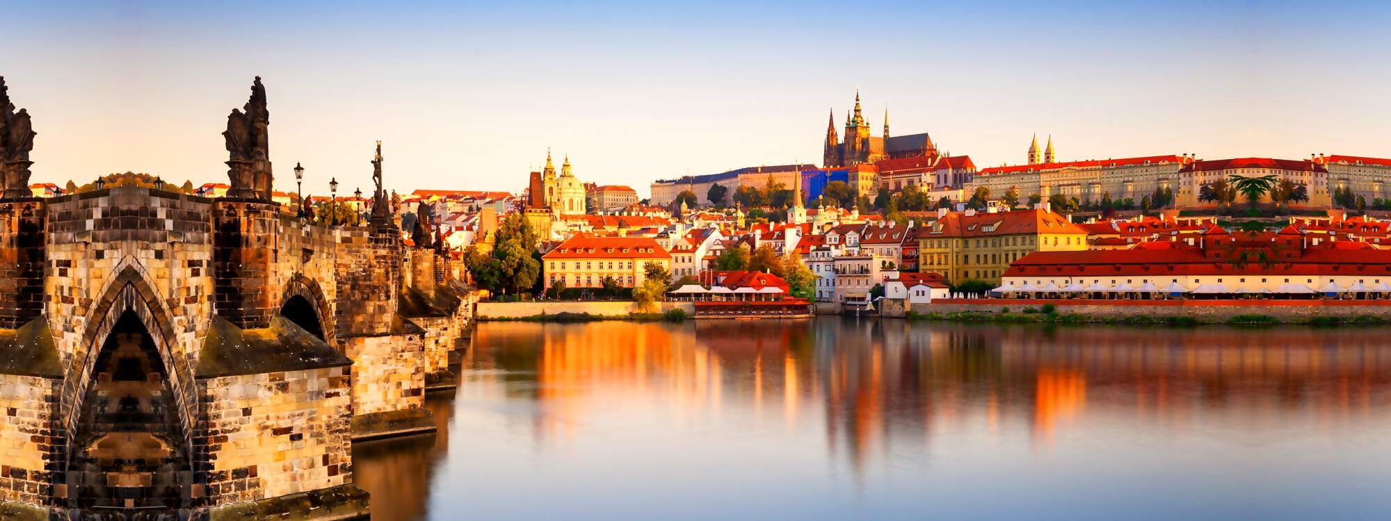 Blick auf die Altstadt mit der Prager Burg und die Karlsbruecke bei Sonnenaufgang